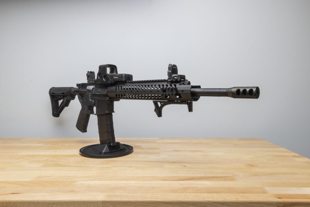 AR-15 rifle mounted securely on a display stand.