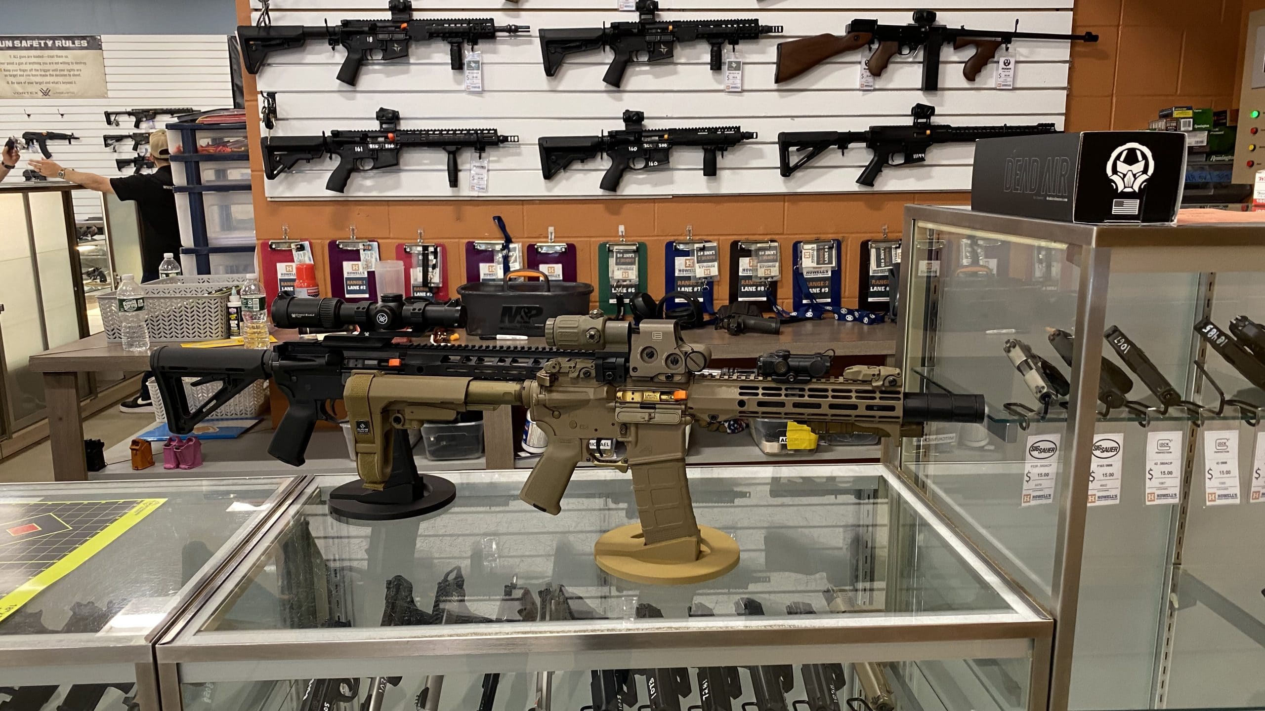 Display stand for firearms in a gun store, showcasing various rifles and pistols